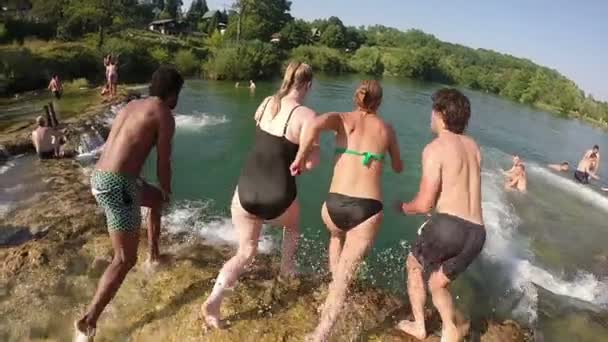 Vrienden springen in de rivier — Stockvideo