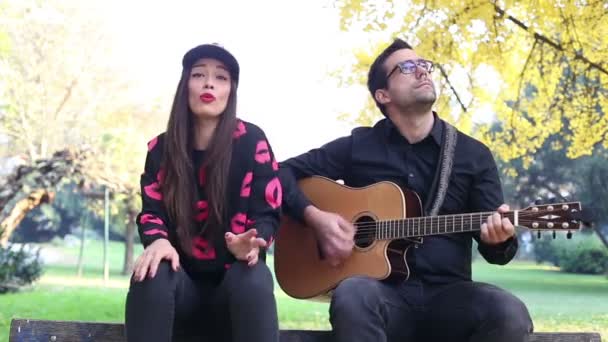 Mujer cantando mientras el hombre toca la guitarra — Vídeo de stock