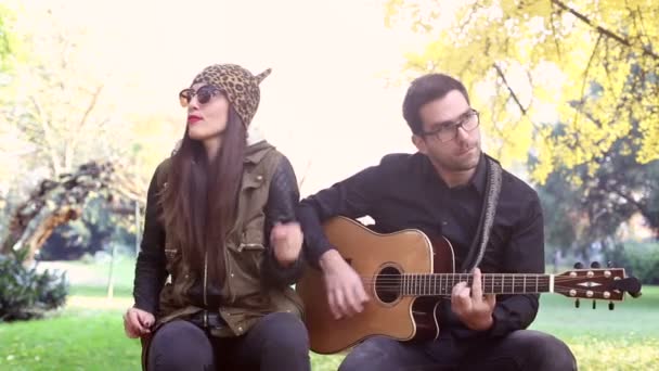 Mujer cantando mientras el hombre toca la guitarra — Vídeo de stock