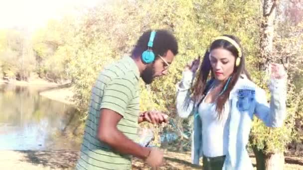 Pareja escuchando música con auriculares — Vídeos de Stock