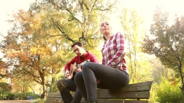 Mujer cantando mientras el hombre toca la guitarra — Vídeos de Stock