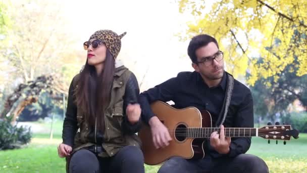 Mujer cantando mientras el hombre toca la guitarra — Vídeos de Stock