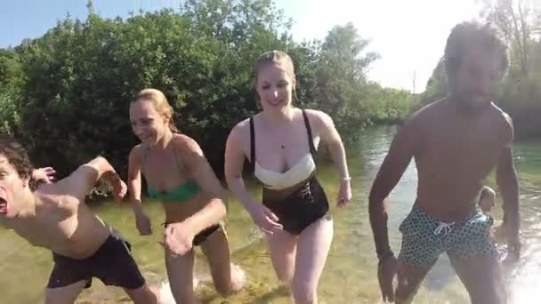 Vrienden springen in de rivier — Stockvideo