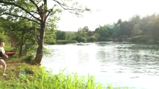 Vrienden lopen en springen in de rivier — Stockvideo