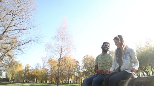 Pareja escuchando música en auriculares — Vídeo de stock