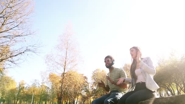 Пара слушает музыку в наушниках — стоковое видео