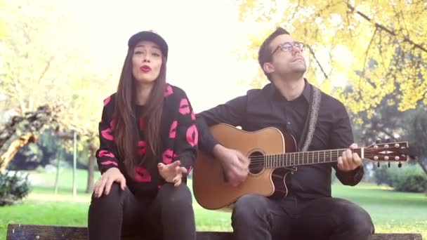 남자가 기타를 연주 하면서 노래 하는 여자 — 비디오