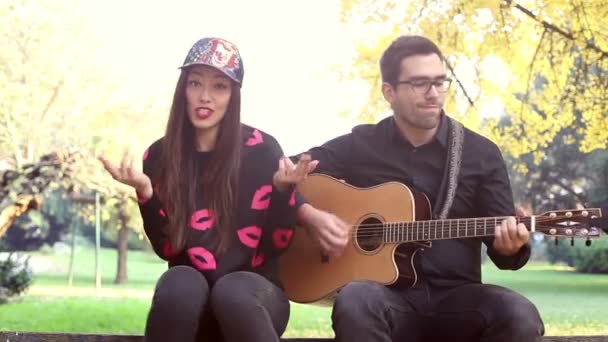 Žena zpívá když člověk hrát na kytaru — Stock video