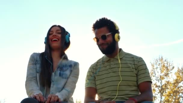 Pareja escuchando música con auriculares — Vídeo de stock