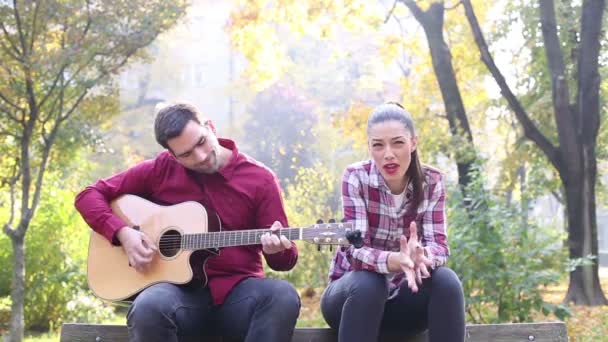 Mann spielt Gitarre, während Frau singt — Stockvideo