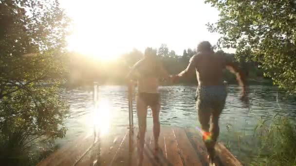 Couple jumping into water — Stock Video