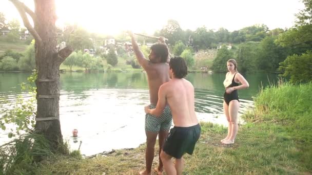 Freunde springen von Seilschaukel in Fluss — Stockvideo