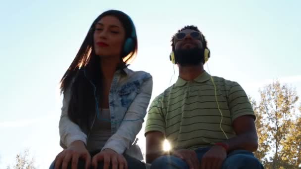 Пара слушающих музыку с наушниками — стоковое видео