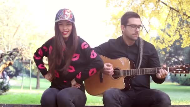 Женщина поет, пока мужчина играет на гитаре — стоковое видео