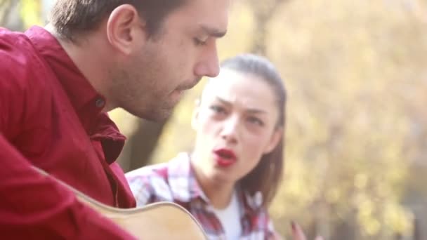 Mujer cantando mientras el hombre toca la guitarra — Vídeos de Stock