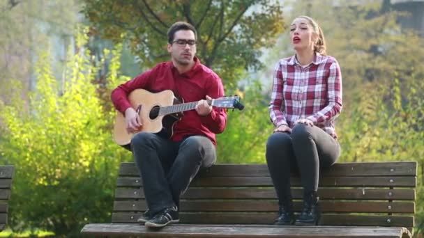 Mann spielt Gitarre und singt mit Frau — Stockvideo