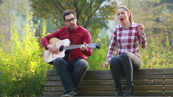 Чоловік грає на гітарі з жінкою — стокове відео