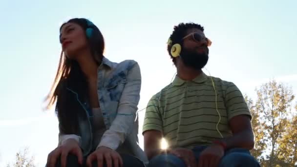 Pareja escuchando música con auriculares — Vídeos de Stock