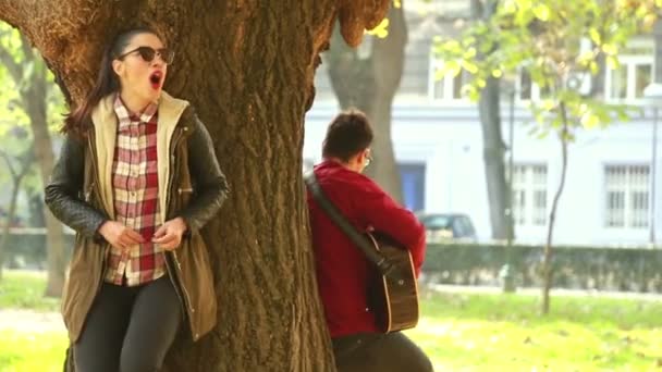 Kvinna som sjunger och man spelar gitarr — Stockvideo