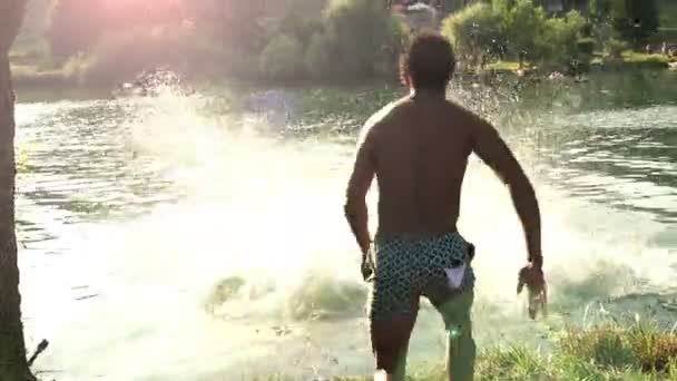 Vrienden springen in de rivier — Stockvideo