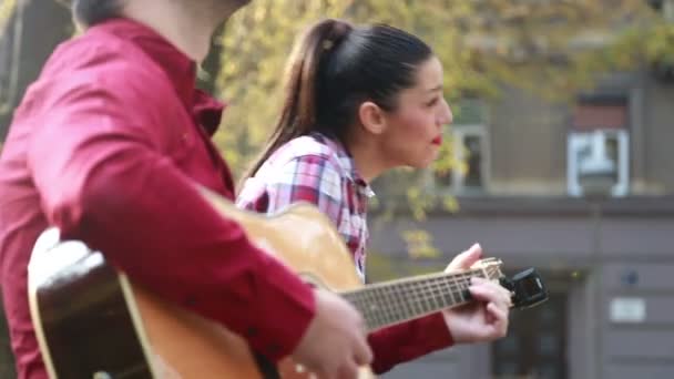 Nő énekel, miközben gitározni ember — Stock videók