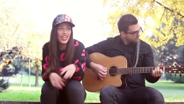 Mujer cantando mientras el hombre toca la guitarra — Vídeo de stock