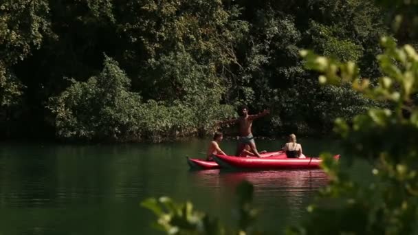 Homem de pé em uma canoa com amigos — Vídeo de Stock