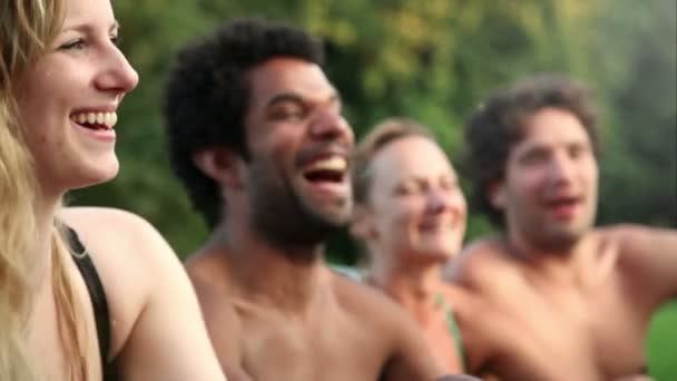 Vrienden lachen zittend in de natuur — Stockvideo