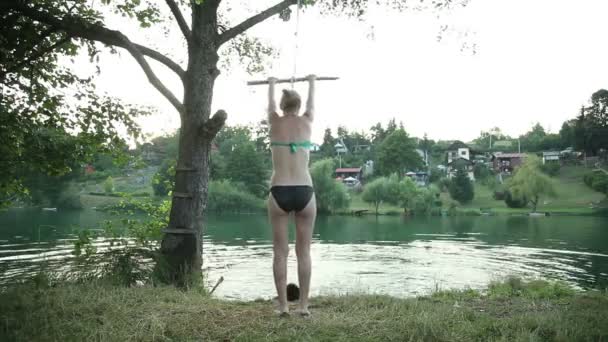 로프 스윙 강으로 뛰어내리는 여자 — 비디오