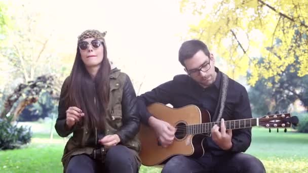 Kobieta śpiewa podczas mężczyzna gra na gitarze — Wideo stockowe