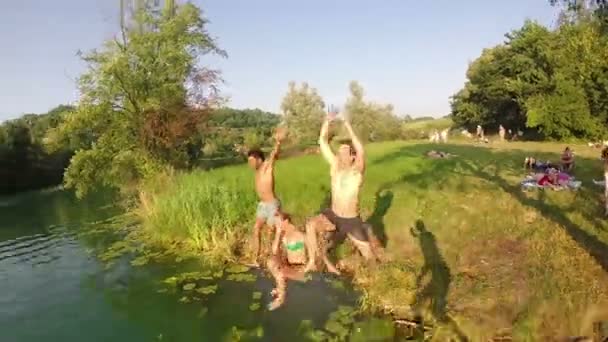 Vrienden springen in de rivier — Stockvideo