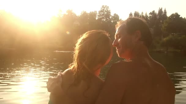 Couple sitting next river at sunset — Stock Video