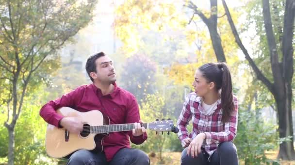 Hombre tocando la guitarra y cantando con mujer — Vídeo de stock