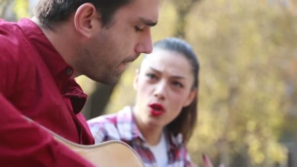 Mujer cantando mientras el hombre toca la guitarra — Vídeo de stock