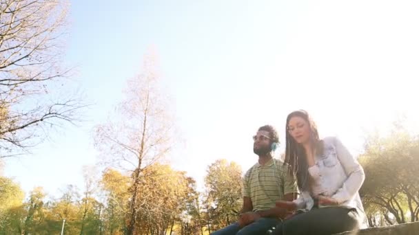 Pareja escuchando música en auriculares — Vídeo de stock