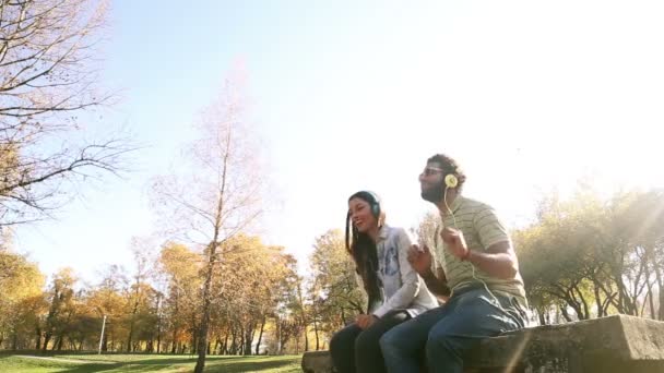 Пара слушает музыку в наушниках — стоковое видео