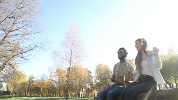 Pareja escuchando música en auriculares — Vídeo de stock