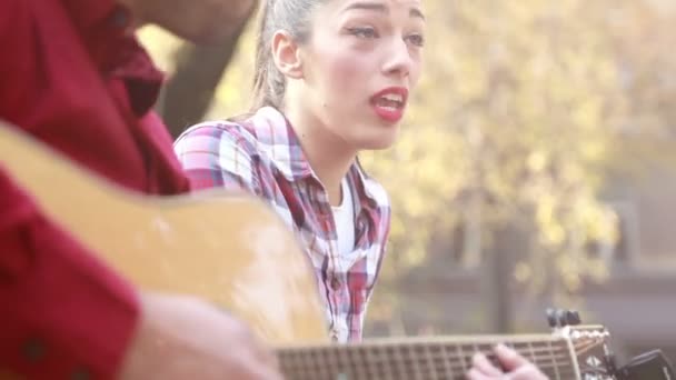 Mujer cantando mientras el hombre toca la guitarra — Vídeo de stock