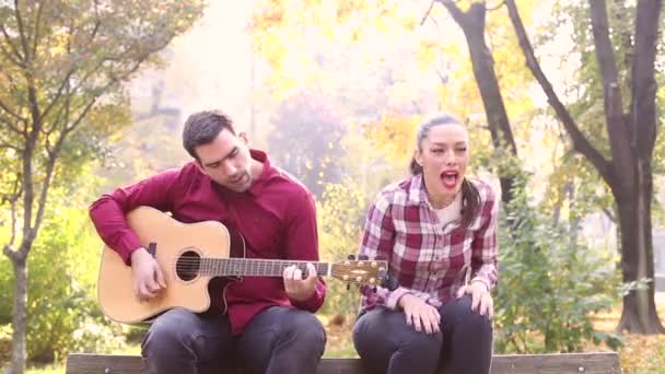 Man playing guitar and singing with woman — Stock Video