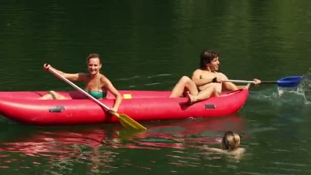 Friends splashing in water with paddles — Stock Video