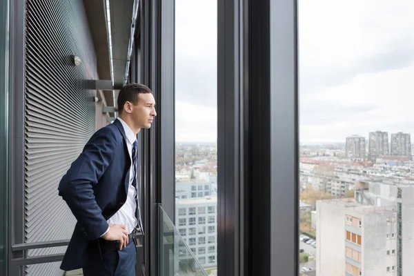 Business man looking out through balcony — Stock Photo, Image