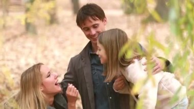 Aile gülüyor ve parkta konuşuyor