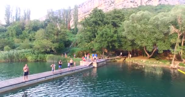 Ludzie stojący na przystań na rzece Krka — Wideo stockowe