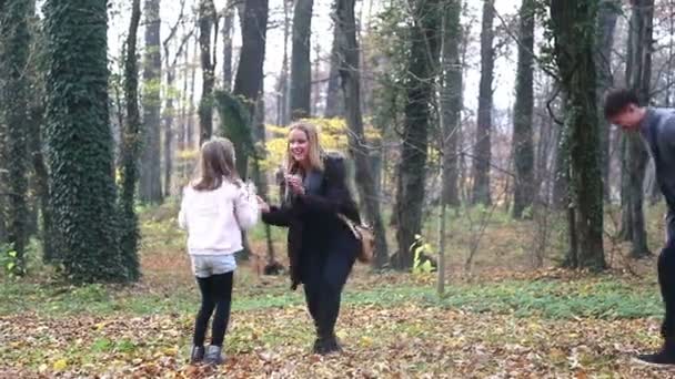 Familjen kasta löv i park — Stockvideo