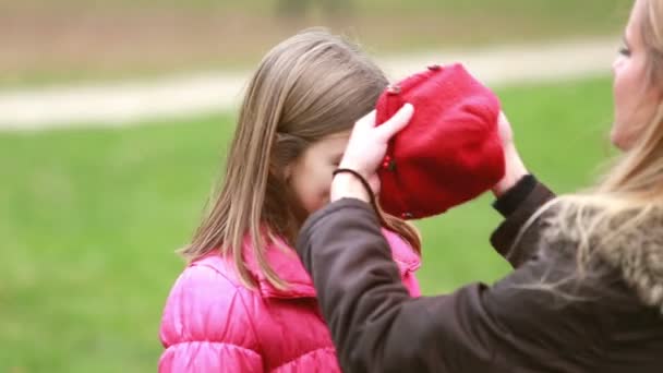 Mamá poniendo gorra en la cabeza de la hija — Vídeo de stock