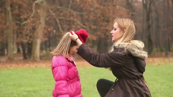 Mère mettre une casquette sur la tête de sa fille — Video