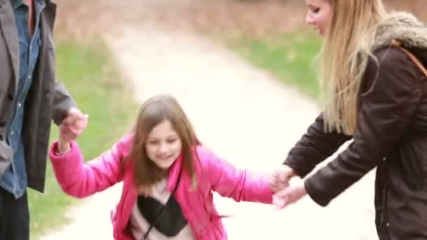 Lány gazdaság kezét a szülők — Stock videók