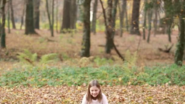 Chica lanzando hojas en parque — Vídeo de stock