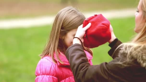 Cap kızının başının üstüne koyarak anne — Stok video