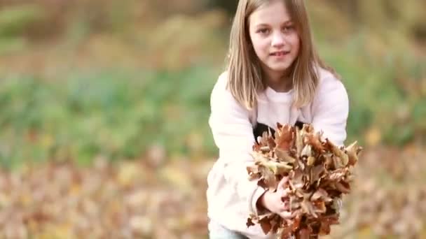 Mädchen wirft Blätter in Park — Stockvideo